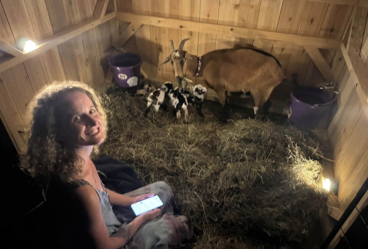 Mariah sitting in the goat pen at night with the new babies