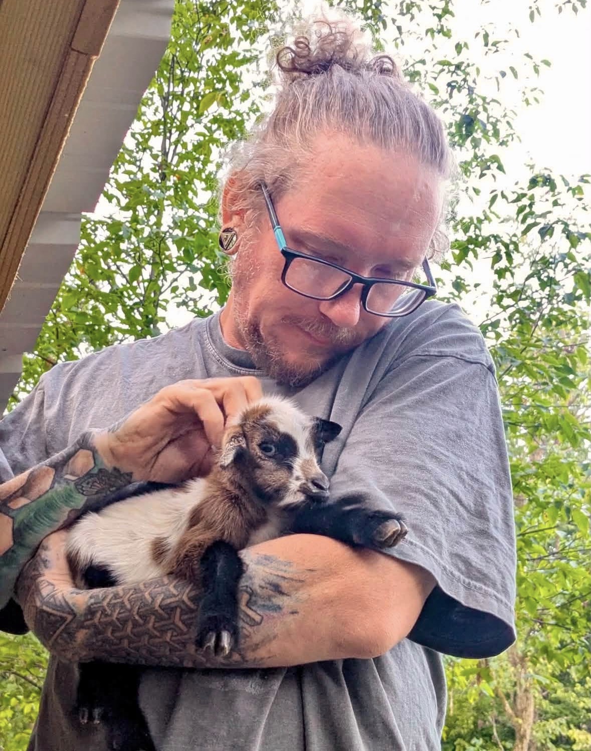 Michael holding a newborn baby goat